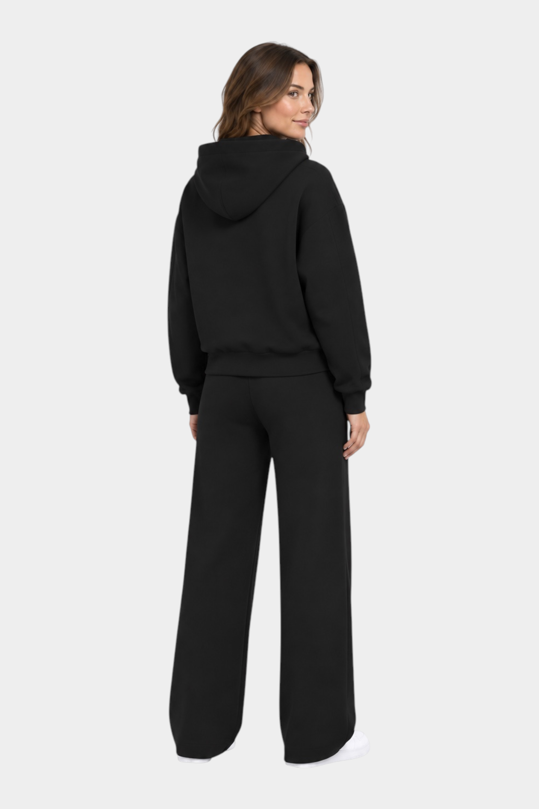 Donna di spalle indossa una felpa con cappuccio e pantaloni jogger neri Follower SRL in stile casual