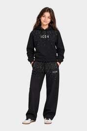 Bambina indossa tuta Follower SRL nera con cappuccio e pantaloni decorati da strass scintillanti e scritta ICON