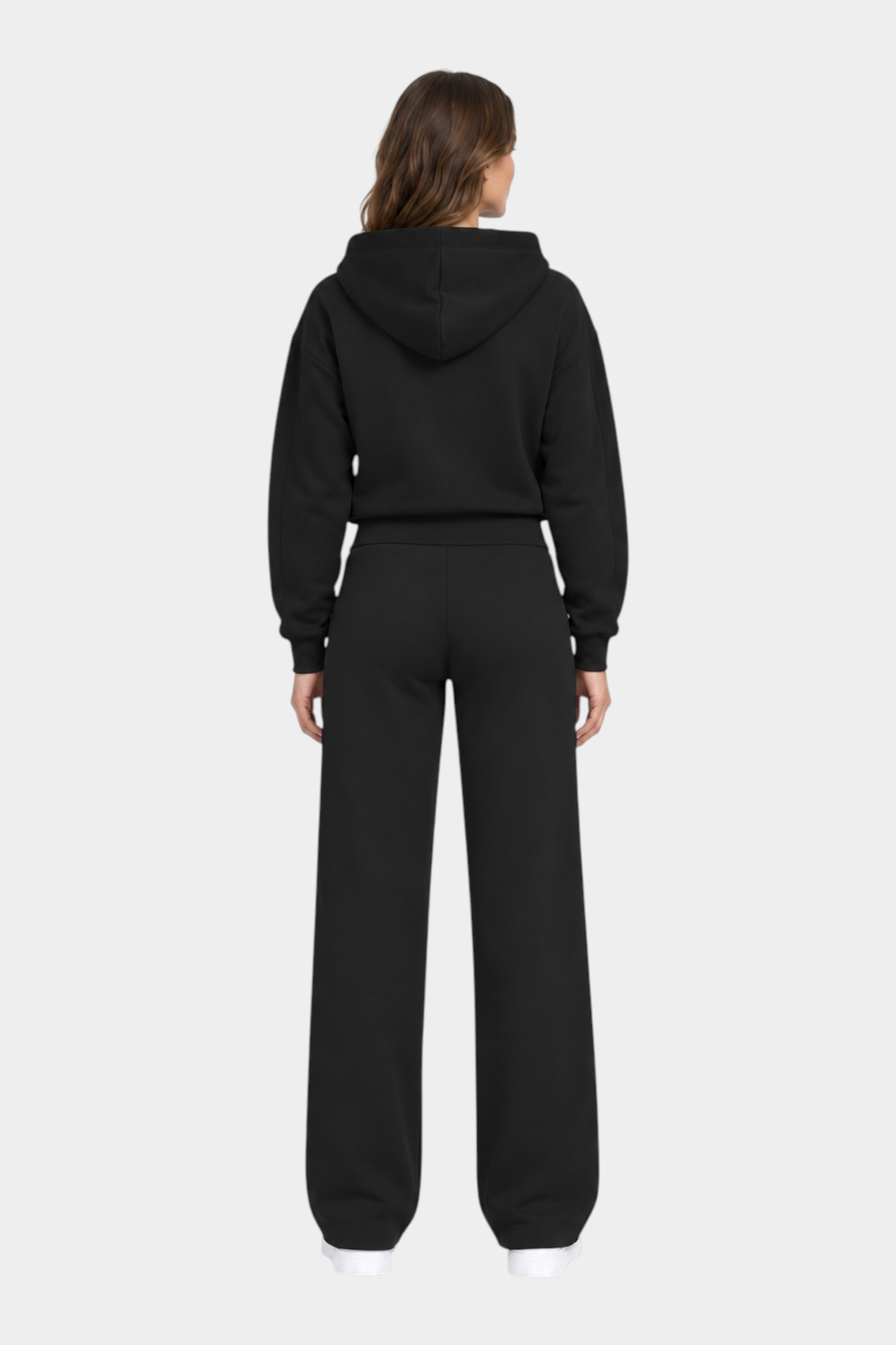 Vista posteriore di una modella che indossa una tuta sportiva nera Follower SRL con felpa con cappuccio e pantaloni