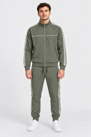 Modello indossa tuta sportiva Follower SRL verde con logo GUESS all-over, giacca con zip e pantaloni jogger