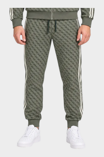 Modello indossa tuta sportiva Follower SRL verde con logo GUESS all-over, giacca con zip e pantaloni jogger
